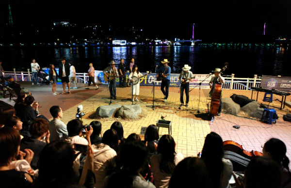 ▲ 낭만버스킹 공연팀이 여수밤바다를 배경으로 연주를 하고 있다.