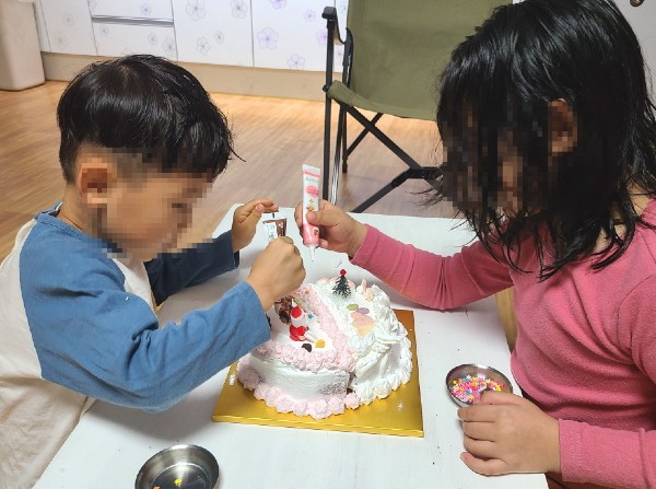 ▲ 여수시 드림스타트가 운영한 ‘우리 같이, 미리메리(Merry) 크리스마스!’ 프로그램을 통해 크리스마스 케이크 만들기를 체험하는 남매의 모습